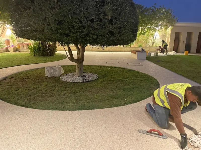 Workers installing resin bound pathway at night in an Abu Dhabi villa