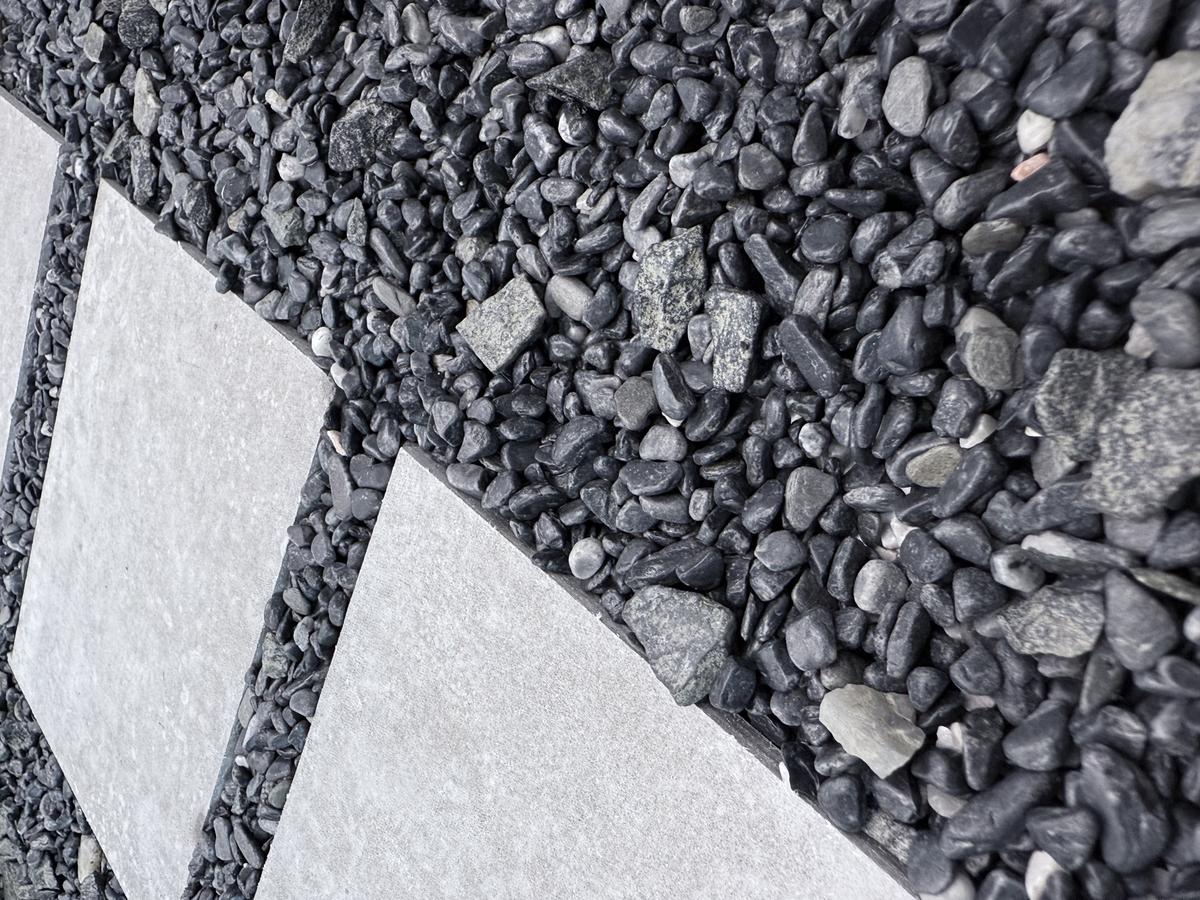 Close-up of pebbles sitting neatly between garden stepping stones