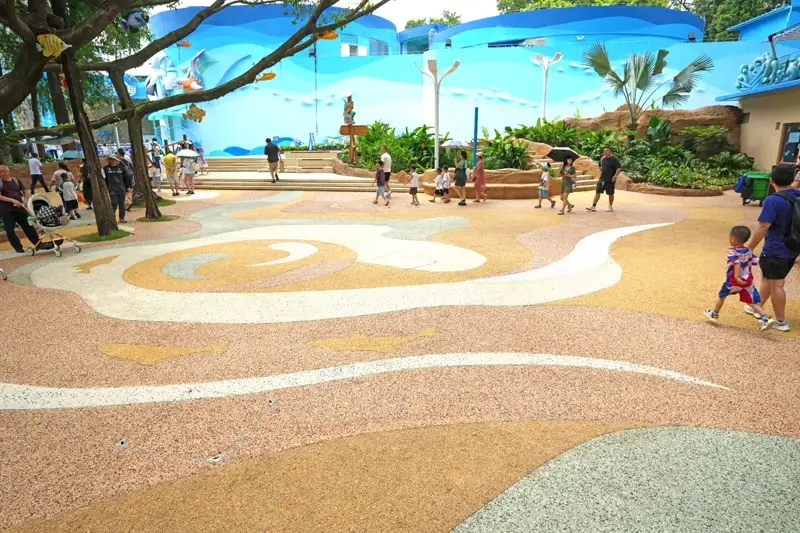 Large-scale decorative stone carpet surface with artistic wave patterns at a commercial venue